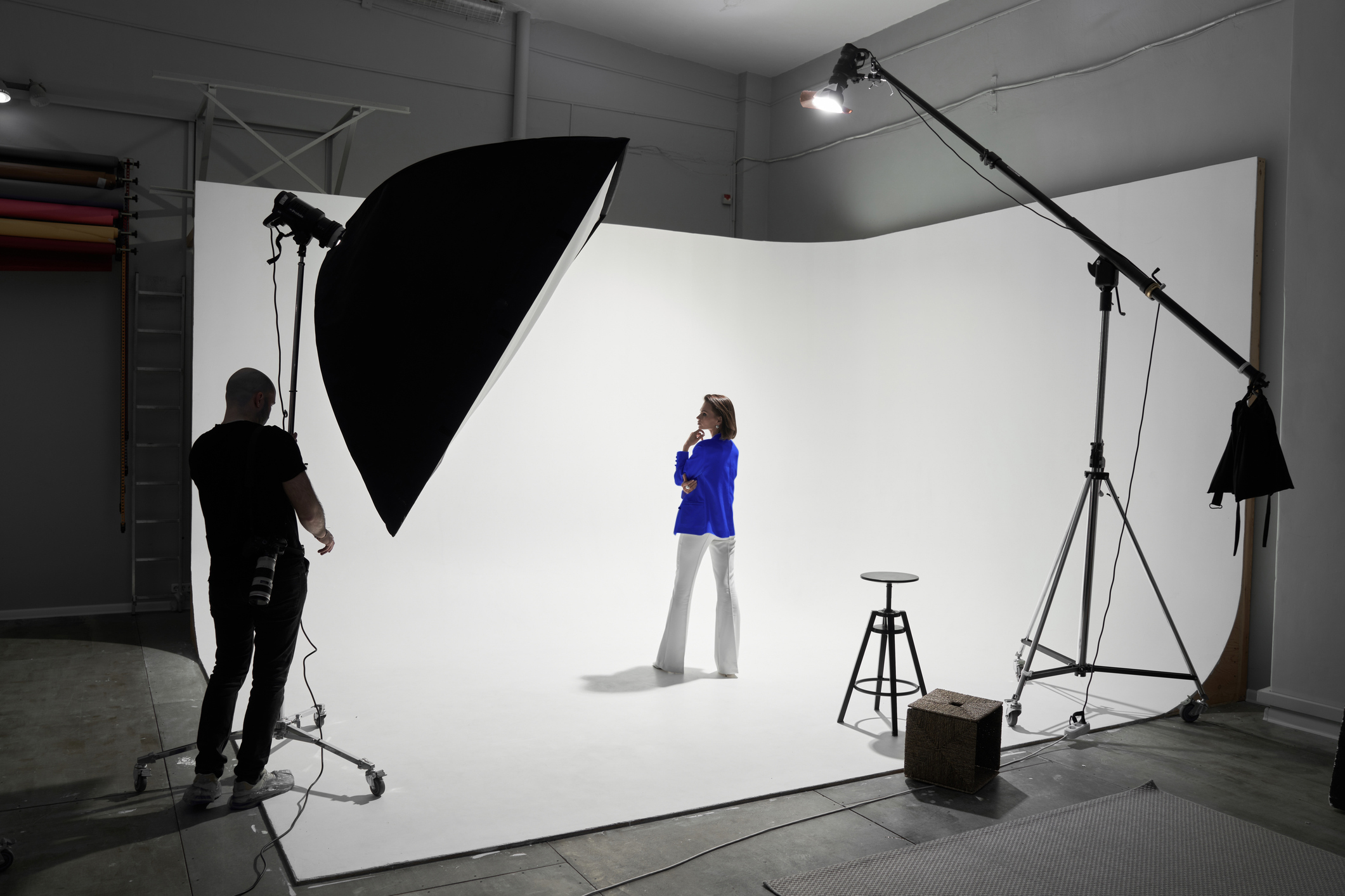Photographe et mannequin sur un plateau studio en cyclorama blanc, l’un des métiers de l’image que l’IA ne standardise pas.